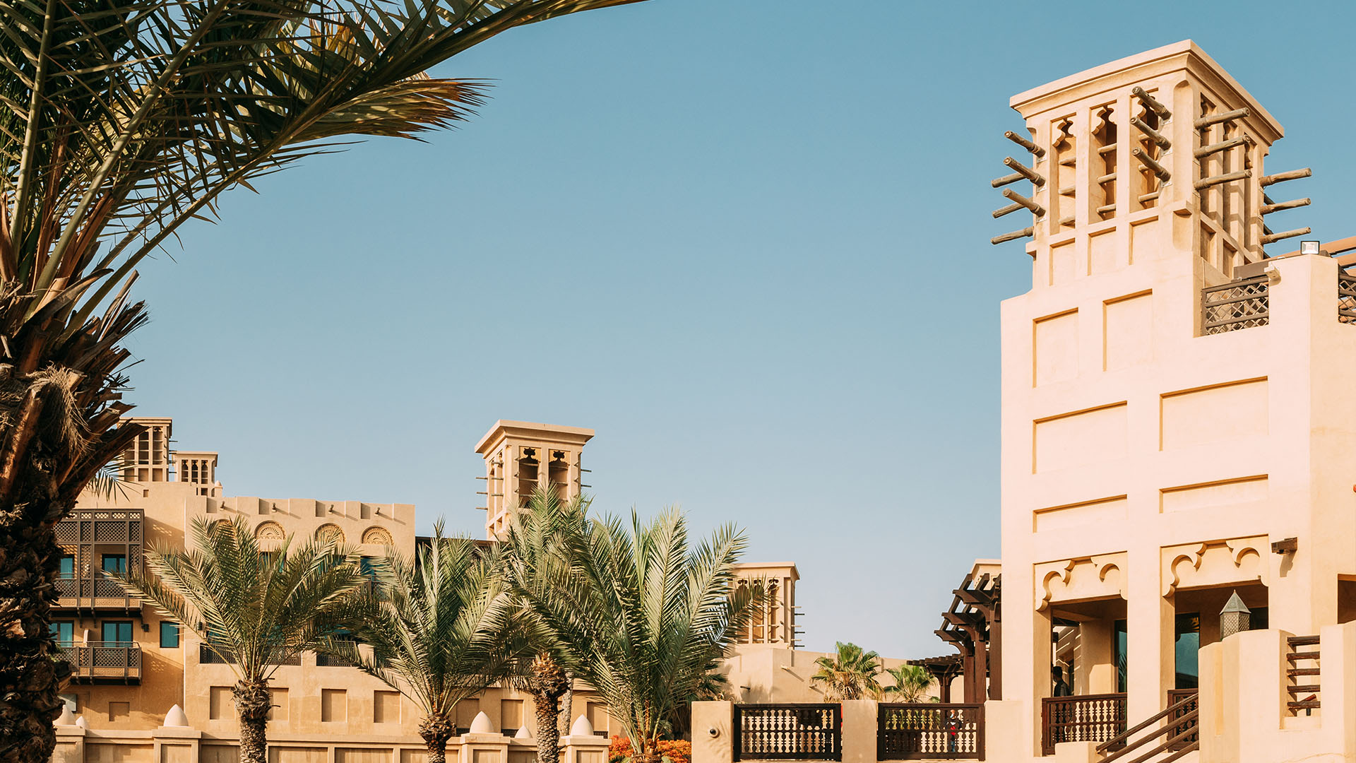 Traditionelle Windtürme in Dubai bei blauem Himmel.